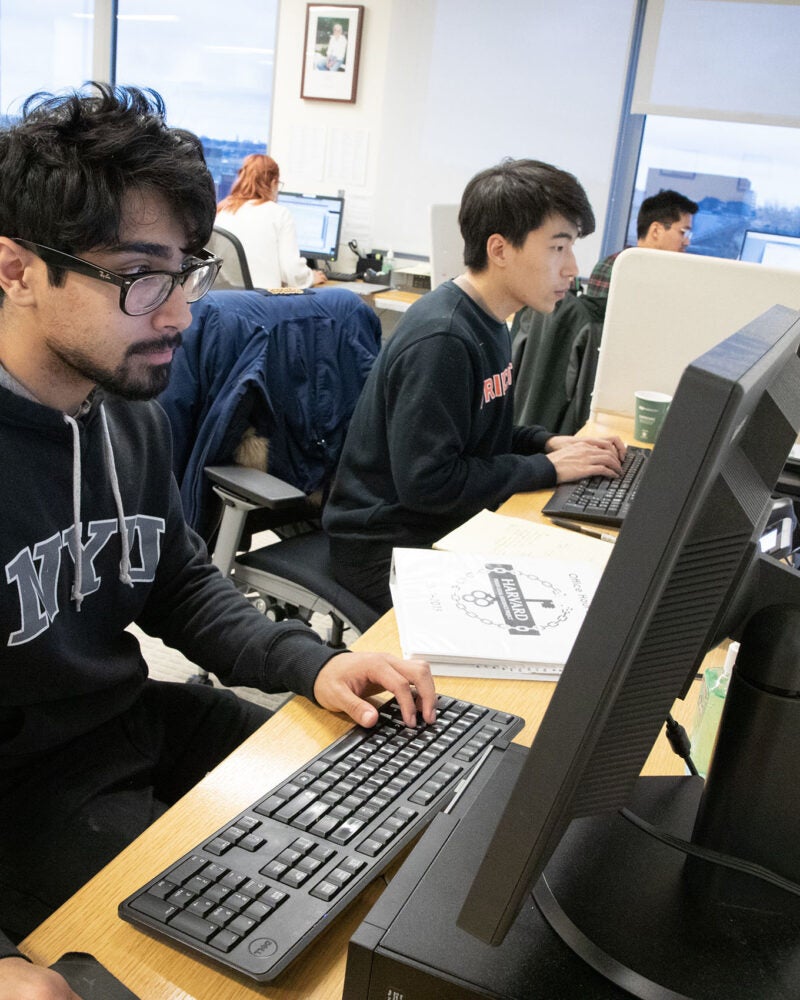 Two students at computers in the PLAP office.