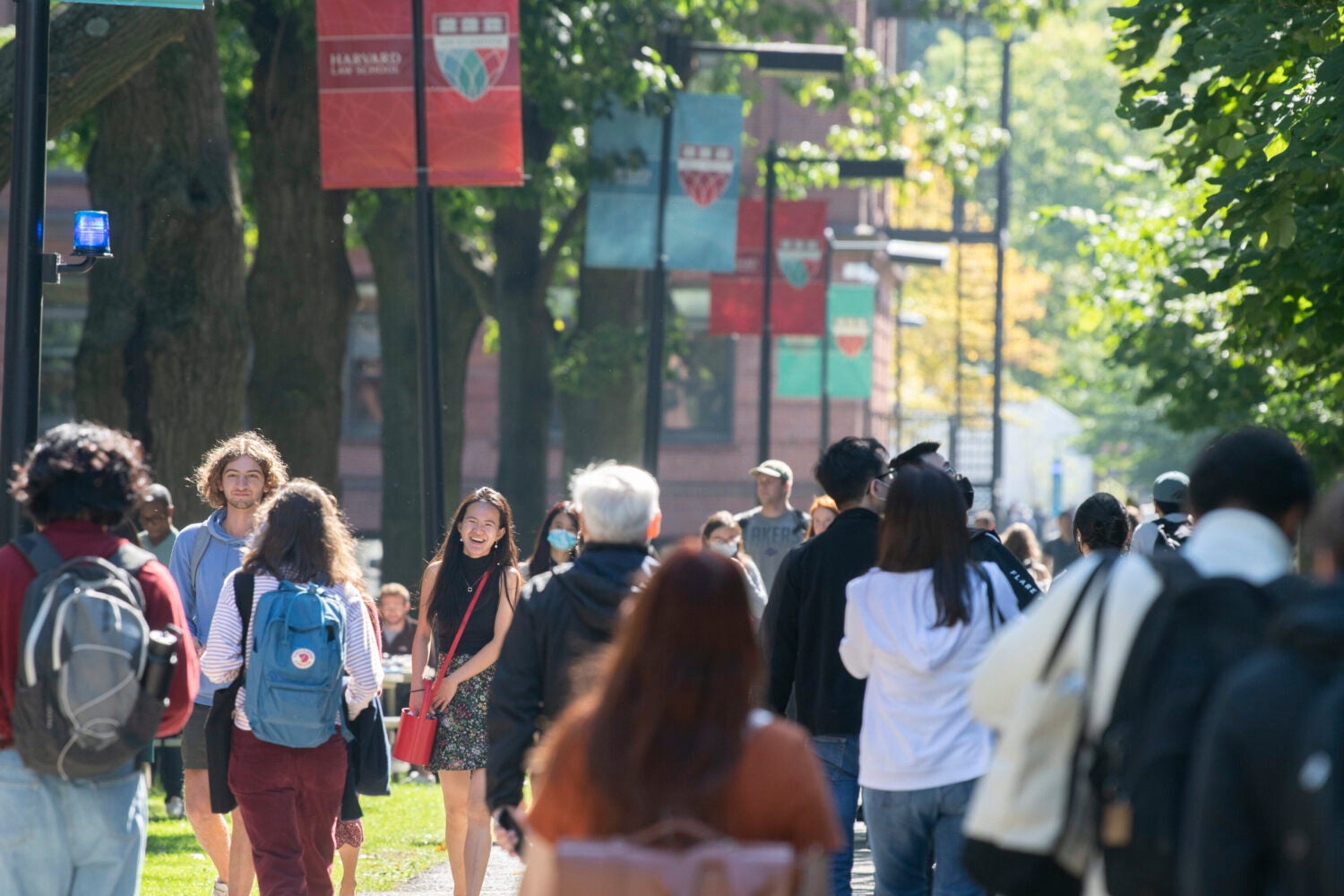 Students walking on the HLS campus with the Red and Green flagpole banners in the background