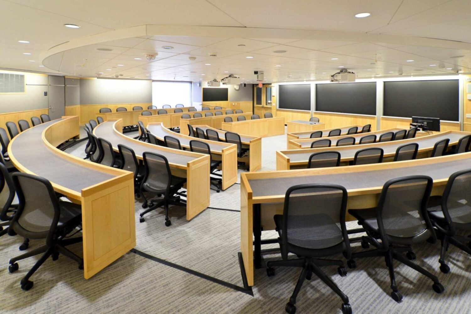 Classroom with circular desks and three chalkboards