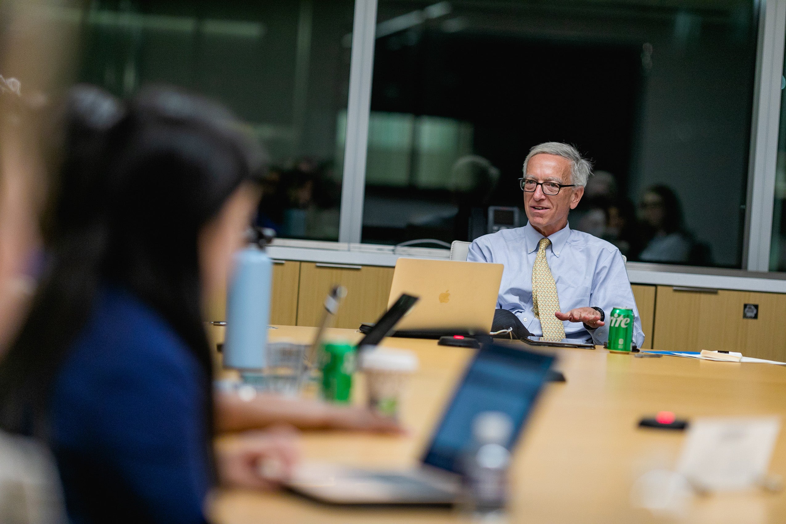 A man making a point at the head of a table of students